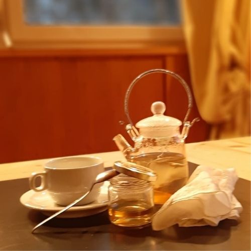 tosse - tazza di te con miele e un fazzoletto usato su tavolo