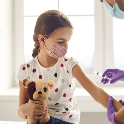 bambina con orsetto di peluche e mascherina che riceve vaccino covid